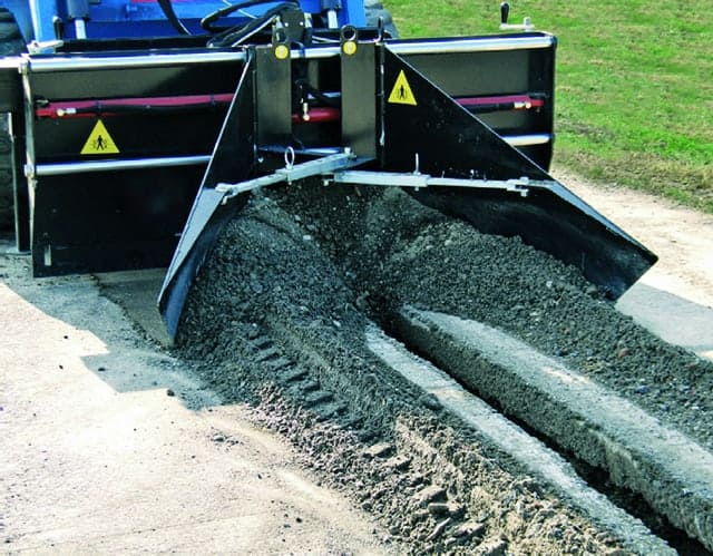 an asphalt paver pushing asphalt into trench